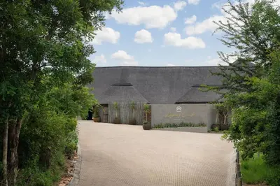 a building with a stone driveway in front of it at Leopard Sands Kruger Park in Skukuza