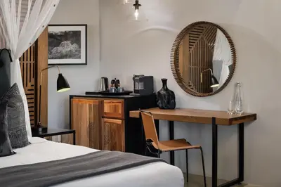 a bedroom with a desk and a mirror and a bed at Leopard Sands Kruger Park in Skukuza