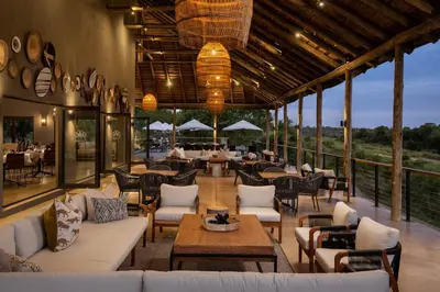 a restaurant with white couches and tables and chairs at Leopard Sands Kruger Park in Skukuza