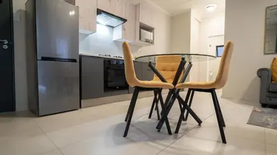 a glass table and two chairs in a kitchen at Modern Midrand Gem in Midrand