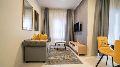 a living room with a couch and a chair at Modern Midrand Gem in Midrand