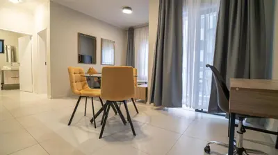 a dining room with a table and yellow chairs at Modern Midrand Gem in Midrand