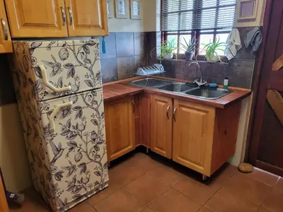 a kitchen with a refrigerator and a sink at Home on a Hill Accommodation in Tzaneen