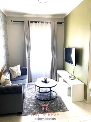 a living room with a couch and a table at Nid de Rêve Accommodation in Midrand