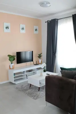 a living room with a tv and a couch at Nid de Rêve Accommodation in Midrand