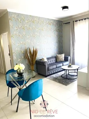 a living room with a couch and a table at Nid de Rêve Accommodation in Midrand