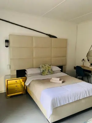 a bedroom with a large white bed and a desk at TnB Guesthouse in Middelburg
