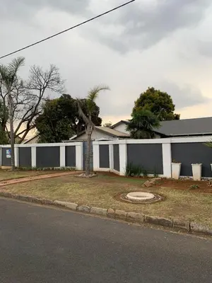 a white and gray house with a palm tree in front of it at TnB Guesthouse in Middelburg