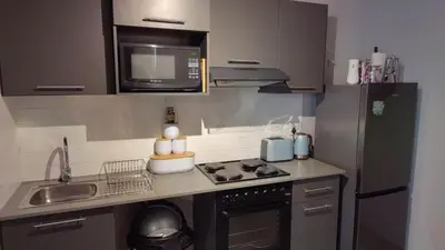 a small kitchen with a stove and a microwave at Circa unit 91 in Pretoria