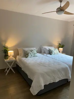 a bedroom with a large bed with a ceiling fan at De Vlei - Private Accommodation in Garsfontein in Pretoria