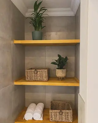 a bathroom with wooden shelves with baskets and plants at De Vlei - Private Accommodation in Garsfontein in Pretoria