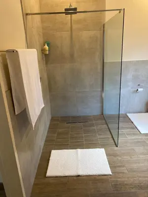 a bathroom with a shower with a glass door at De Vlei - Private Accommodation in Garsfontein in Pretoria