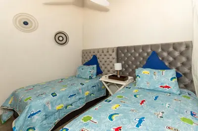 a bedroom with two beds and a bedspread with cars on it at Kruger Park Lodge Unit No. 253 in Hazyview
