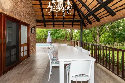 a white dining table and chairs on a deck at Kruger Park Lodge Unit No. 253 in Hazyview