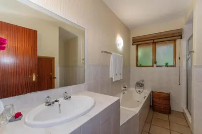 a bathroom with a sink and a bath tub and a tubermott at Kruger Park Lodge Unit No. 516 in Hazyview