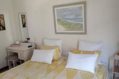 a bedroom with a bed with pillows and a desk at Pecanwood Estate Cosy home 3 bedrooms with pool in Hartbeespoort