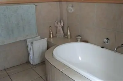 a bathroom with a white tub and a sink at Pecanwood Estate Cosy home 3 bedrooms with pool in Hartbeespoort