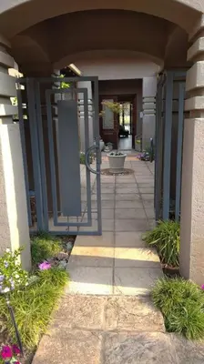 an entrance to a building with a walk way at Pecanwood Estate Cosy home 3 bedrooms with pool in Hartbeespoort