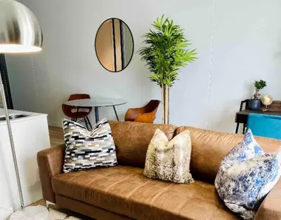 a living room with a brown couch with pillows at Views on the six in Midrand