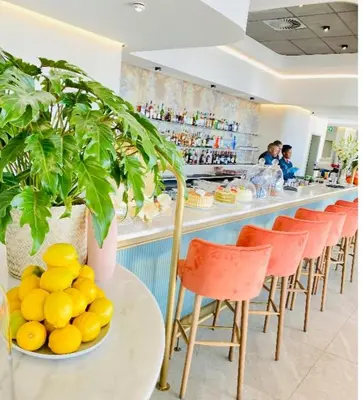 a bar with orange chairs and a table with a bowl of oranges at Views on the six in Midrand