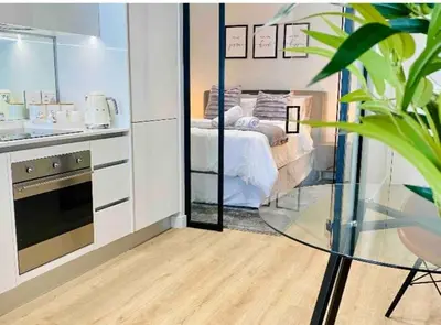 a kitchen with a bed and a glass table in a room at Views on the six in Midrand