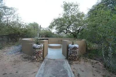 a bench sitting in the middle of a field with trees at Shiandi Villa in Hoedspruit