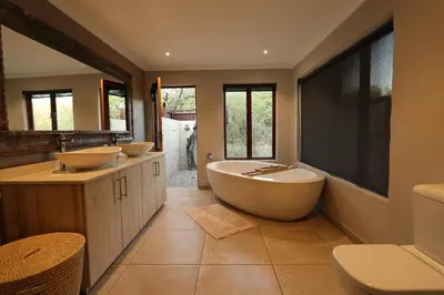 a bathroom with two sinks and a tub at Shiandi Villa in Hoedspruit