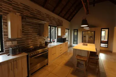 a large kitchen with a stove and a counter top at Shiandi Villa in Hoedspruit
