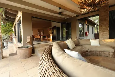 a living room with a couch and a patio at Shiandi Villa in Hoedspruit