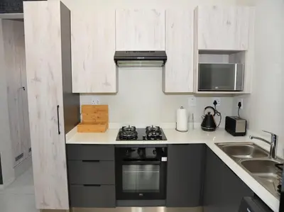 a kitchen with a stove top oven next to a sink at ELcaro Luxury Villas-The Cave in Midrand