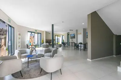 a lobby with chairs and tables in a building at ELcaro Luxury Villas-The Cave in Midrand