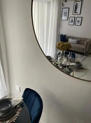 a mirror reflecting a living room with a table and a couch at Elcaro Luxury Villas-Royal Abode in Midrand