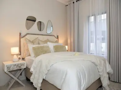 a bedroom with a white bed with mirrors on the wall at Elcaro Luxury Villas-Royal Abode in Midrand