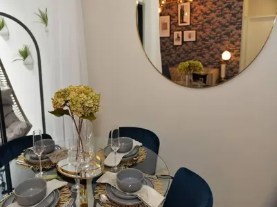 a glass table with a vase of flowers and a mirror at Elcaro Luxury Villas-Royal Abode in Midrand