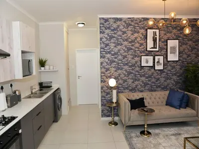 a kitchen and a living room with a couch at Elcaro Luxury Villas-Royal Abode in Midrand