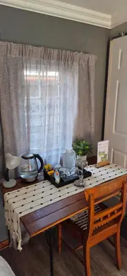 a table with a tray of food on it in front of a window at Bo Kamer Guesthouse in Ermelo