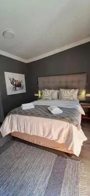 a bedroom with a large bed in a room at Bo Kamer Guesthouse in Ermelo