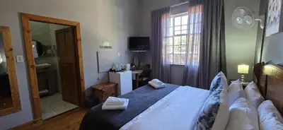 a bedroom with a large bed with towels on it at Bo Kamer Guesthouse in Ermelo