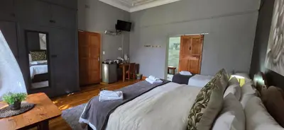 a bedroom with a large bed and a couch at Bo Kamer Guesthouse in Ermelo