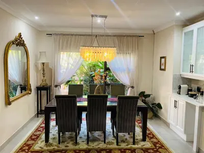 a dining room table with chairs and a chandelier at Blissful Bracelet in Nelspruit