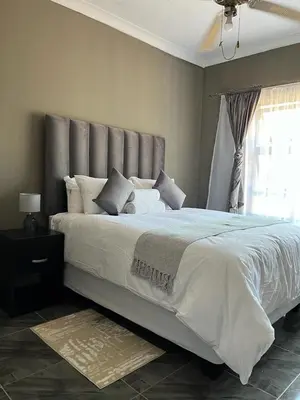 a bedroom with a large white bed with a window at SERENE ACCOMMODATION PALACE in Bela-Bela