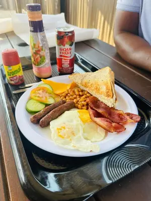 a plate of breakfast food with eggs bacon beans and toast at MBT Guesthouses in Ga-Mothiba