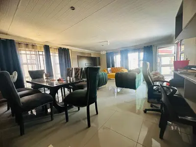 a living room with a dining room table and chairs at MBT Guesthouses in Ga-Mothiba
