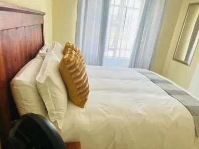 a bed with two pillows on it with a window at MBT Guesthouses in Ga-Mothiba