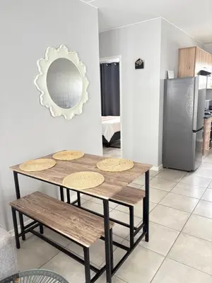 a table with benches and a mirror in a kitchen at Monochrome View in Nelspruit