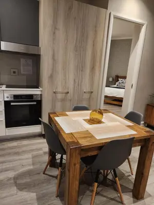 a dining room with a wooden table and chairs at Menlyn Maine Residences 721 in Pretoria