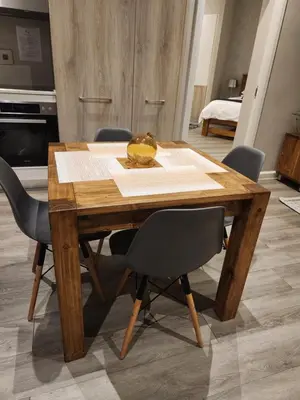 a wooden dining room table with chairs and a kitchen at Menlyn Maine Residences 721 in Pretoria