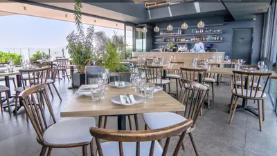 a dining room with wooden tables and chairs at Menlyn Maine Residences 721 in Pretoria