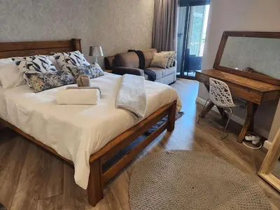 a bedroom with a large bed and a couch at Menlyn Maine Residences 721 in Pretoria