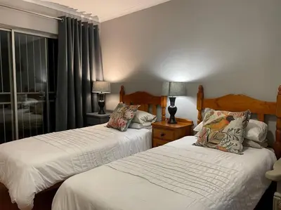 a bedroom with two beds and a window at Magalies House in Pretoria